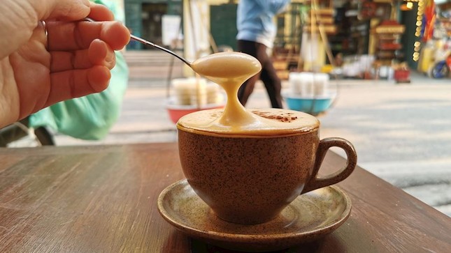 Cà phê phin đen được đổ vào lớp trứng bông, tạo nên một lớp bọt thơm ngon (Ảnh: TasteAtlas).
