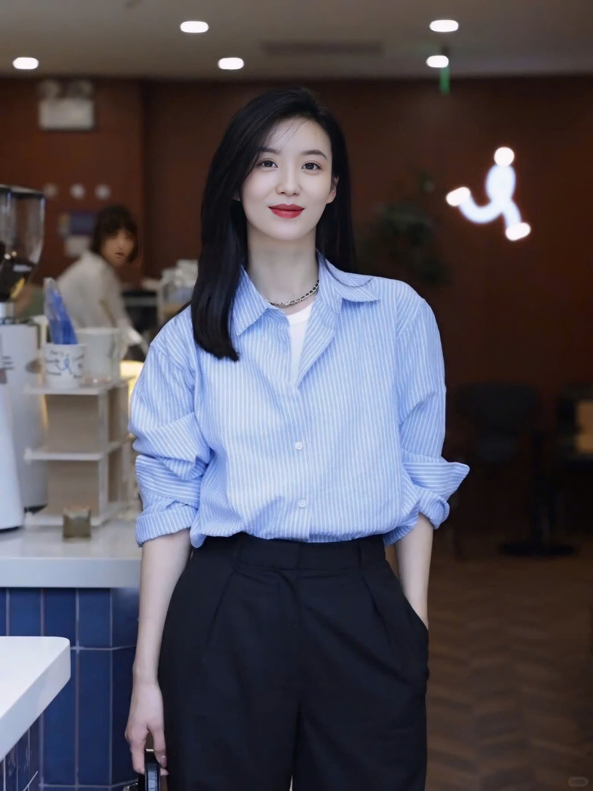 Áo sơ mi xanh sọc kết hợp cùng quần tây ống rộng màu tối tạo nên vẻ ngoài thanh lịch, phù hợp với mọi cô nàng văn phòng. Nếu tiết trời se lạnh, bạn có thể khoác thêm chiếc áo jacket màu đen để tăng độ ấm áp, đồng thời tạo điểm nhấn cho trang phục thêm cuốn hút hơn.