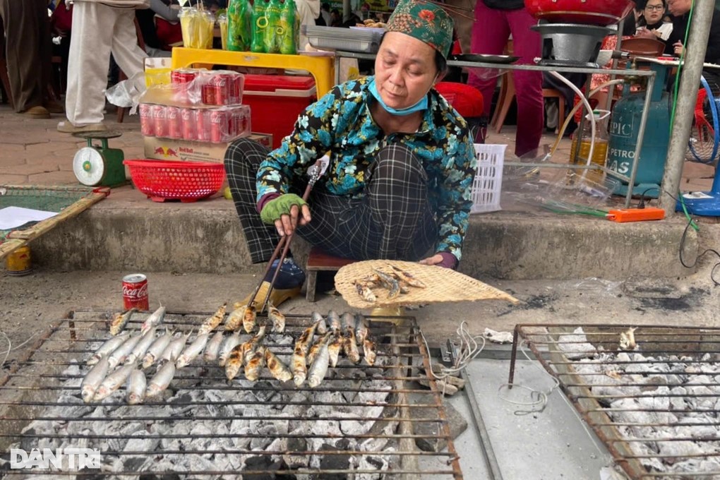 Bà Quyết là người làm nghề nướng cá trích tại Đền Cờn đã hơn chục năm nay đang gắp cá cho thực khách.