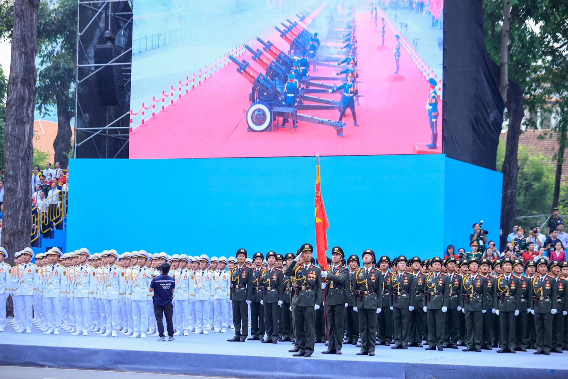 nghi lễ chào cờ trong tiếng rền vang của 21 loạt đại bác do đội pháo lễ thực hiện tại bến Bạch Đằng, Quận 1, TPHCM