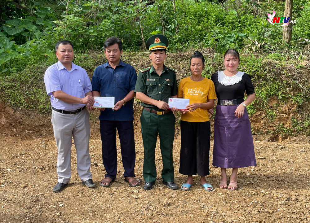 Đại diện Đồn Biên phòng Nhôn Mai và địa phương trao tiền hỗ trợ cho các gia đình.