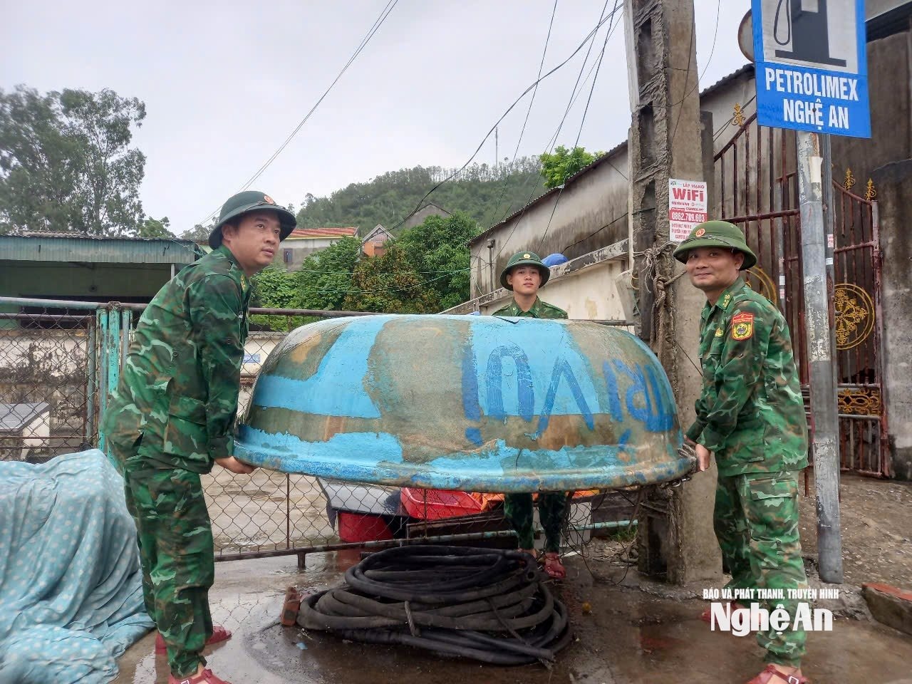 Lực lượng Đồn biên phòng Quỳnh Phương giúp ngư dân phường Tân Mai thu dọn đồ dùng trên tàu thuyền, ngư lưới cụ vào bờ an toàn. Ảnh: Hoài Thu