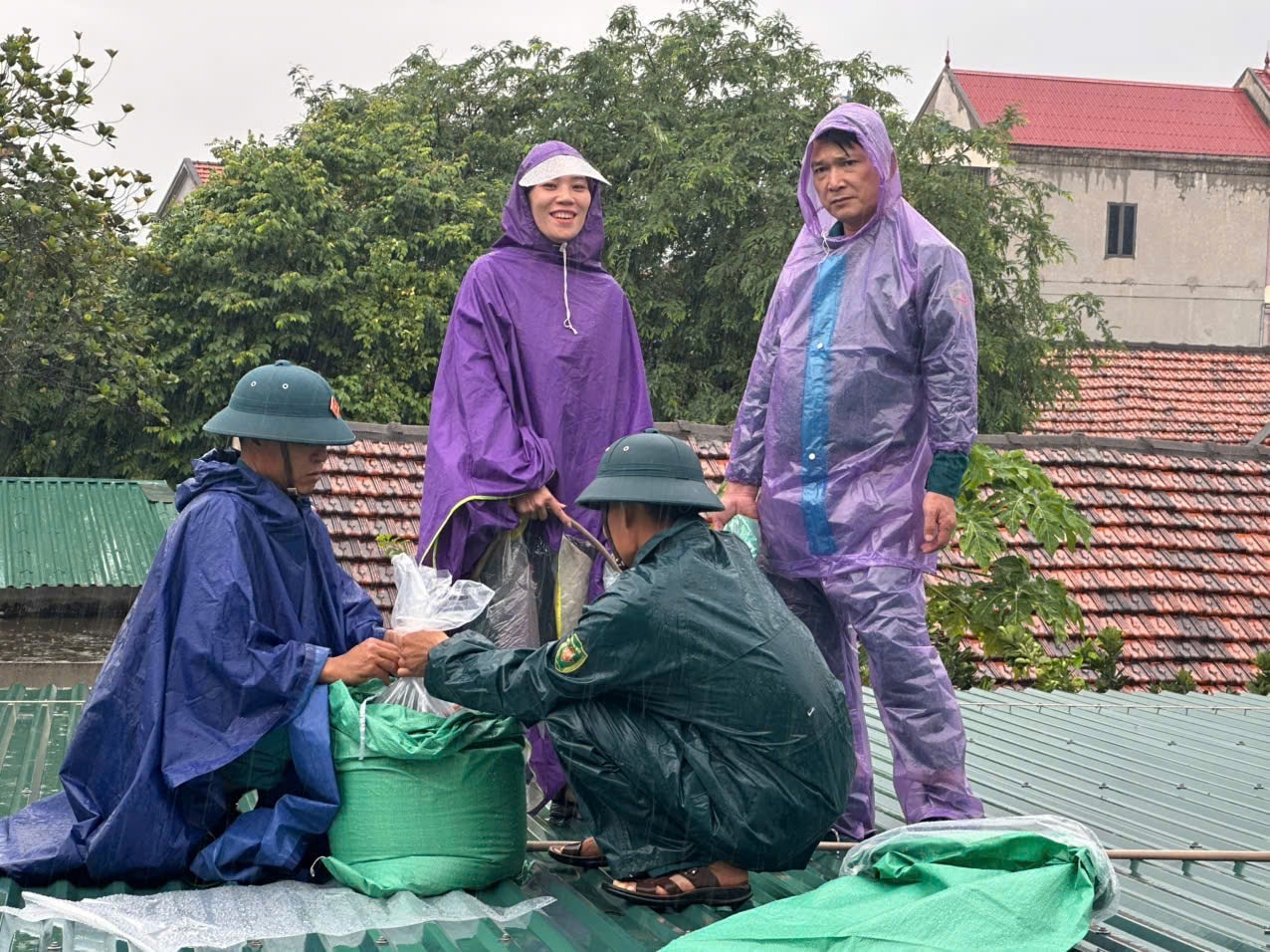 Người dân phường Tân Mai sử dụng cát và nước bỏ trong các bao bì chống thấm để chặn các mái tôn chống gió lốc. Ảnh: Hoài Thu