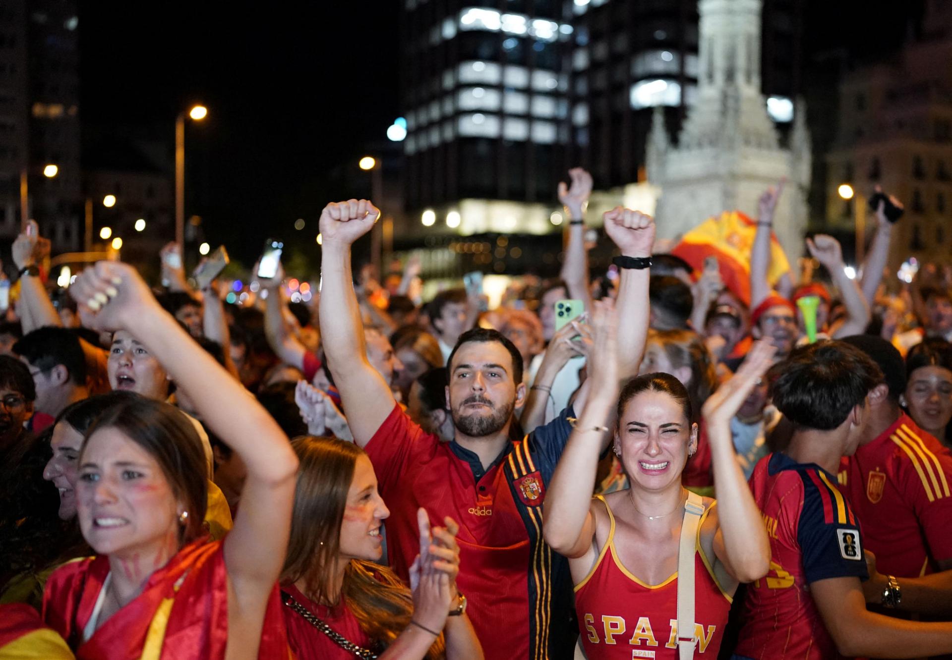 Cổ động viên Tây Ban Nha ăn mừng chiến thắng qua màn hình lớn tại khu vực Fanzone thuộc quảng trường Colon (Thủ đô Madrid), sau khi trận chung kết World Cup 2026 khép lại ngày 19/7. Ảnh: AFP