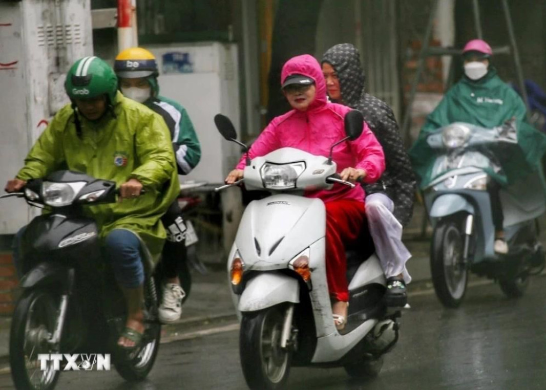 Người dân co ro trong mưa lạnh sáng 1/12.