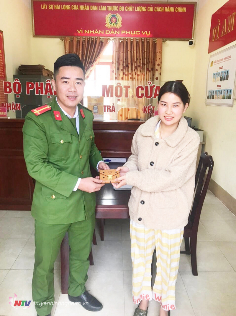 Trung úy Trương Vũ Đạt trao trả chiếc ví cho chị T.T.M.