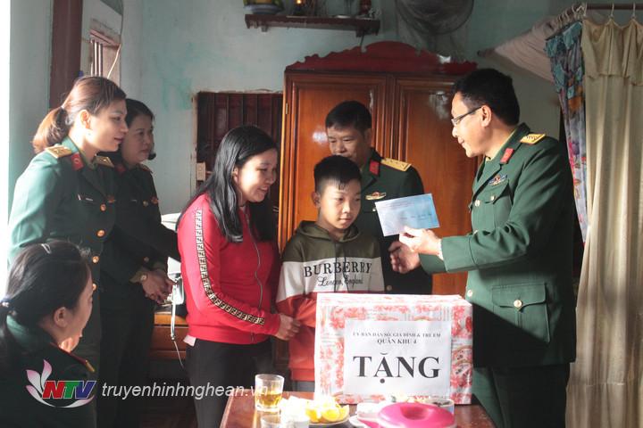 Đại diện Ủy ban DS, GĐ&TE Quân khu 4 trao quà gia đình cháu Lê Minh Bách, con trai của Đại úy QNCN Lê Ngọc Hương  - Nhân viên Quân y Lữ đoàn Pháo binh 16. Cháu Bách bị bệnh thông liên thất đã phẩu thuật.