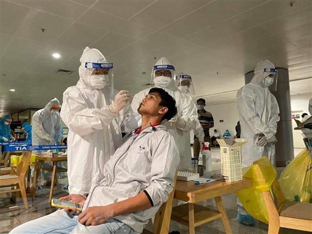 Nhân viên y tế lấy mẫu xét nghiệm cho người làm việc tại sân bay Tân Sơn Nhất.