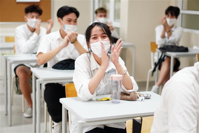 Học sinh đeo khẩu trang, ngồi giãn cách trong lớp học.