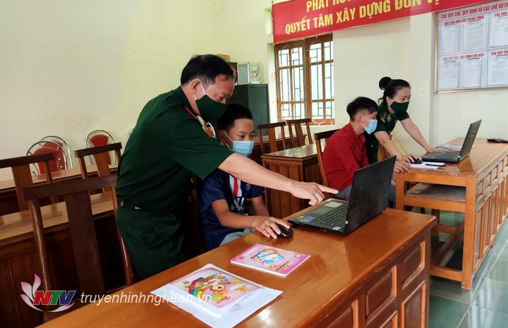Cán bộ đồn Biên phòng Nậm Càn hỗ trợ phương tiện và giúp đỡ 2 con nuôi của đơn vị học trực tuyến tại đồn.