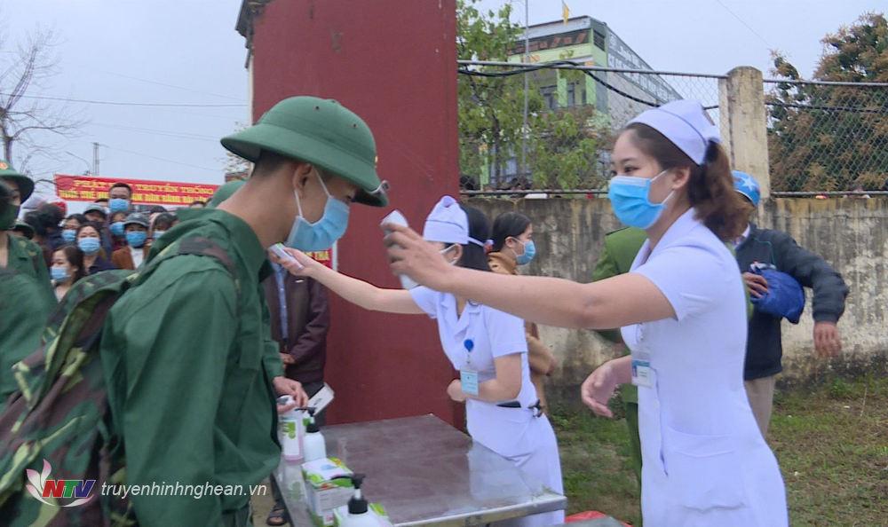 Kiểm tra thân nhiệt các tân binh trước khi vào khu vực tổ chức lễ giao nhận quân.