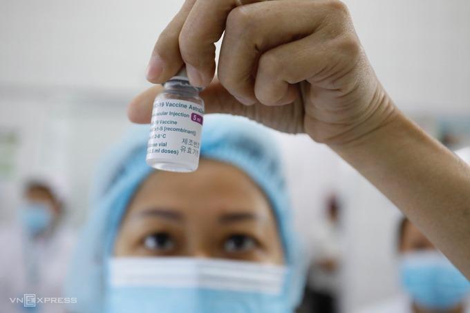 Nhân viên y tế Bệnh viện Bệnh Nhiệt đới TP HCM kiểm tra lọ vaccine AstraZeneca trước khi bắt đầu tiêm chủng ngày 8/3.