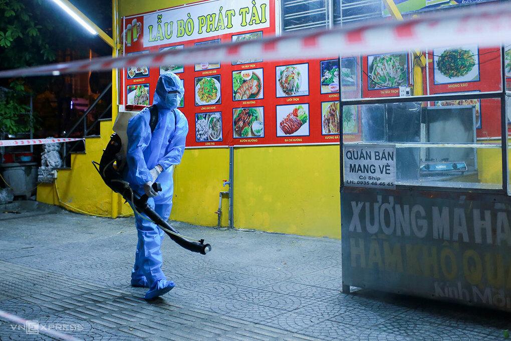 Nhân viên y tế phun khử khuẩn khu hàng quán, dân cư trước cổng Khu công nghiệp An Đồn. 