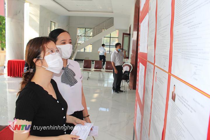 Cử tri theo dõi danh sách ứng cử viên tại khu vực bỏ phiếu.