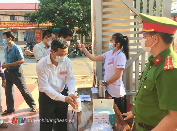 Cử tri được đo thân nhiệt và sát khuẩn tay trước khi vào khu vực bỏ phiếu
