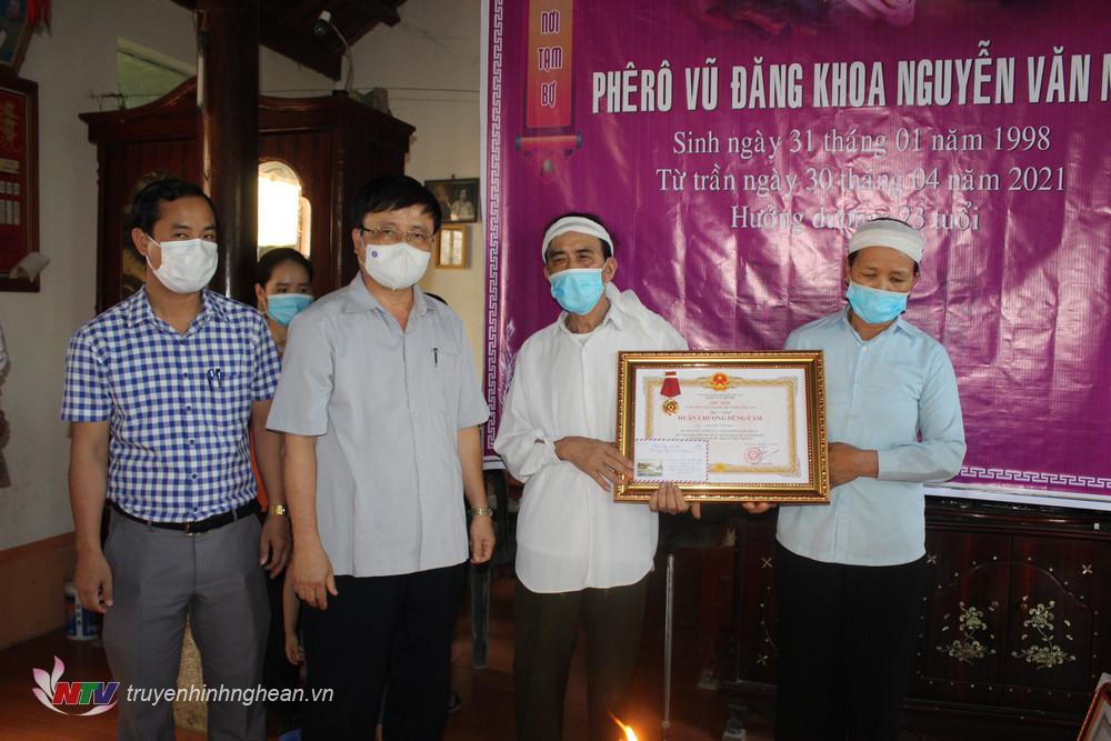 Thừa ủy quyền của PG88 go Bắn cá nước, Phó chủ tịch UBND tỉnh Bùi Đình Long trao quyết định truy tặng Huân chương dũng cảm cho sinh viên Nguyễn Văn Nhã