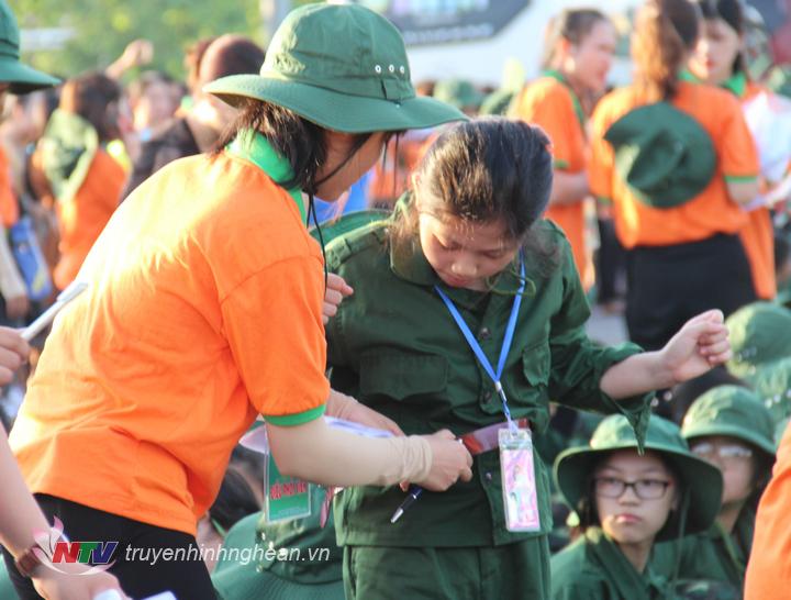 Tình nguyện viên giúp đỡ học viên chỉnh trang trang phục.
