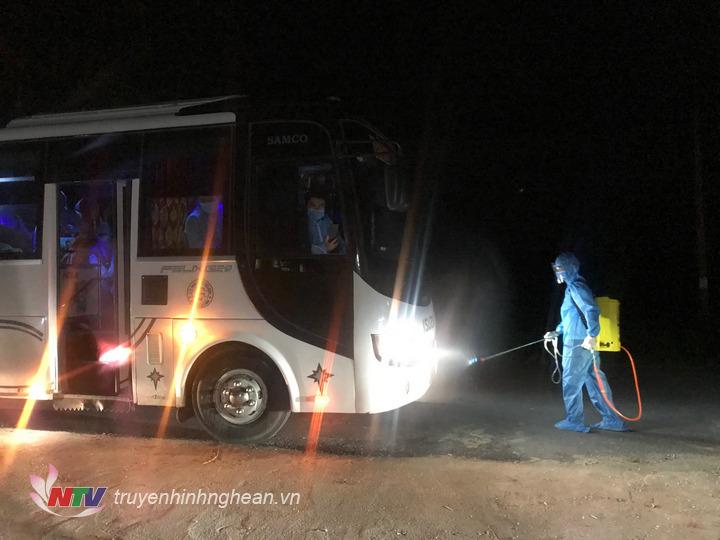 Phun khử khuẩn xe đưa đón công dân là lao động ở Bắc Giang trở về địa phương.
