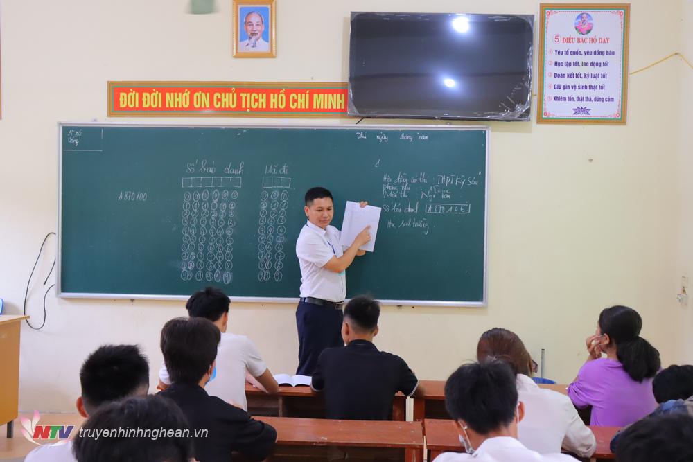 Giám thị hướng dẫn thí sinh điền thông tin vào giấy làm bài thi đúng quy định.