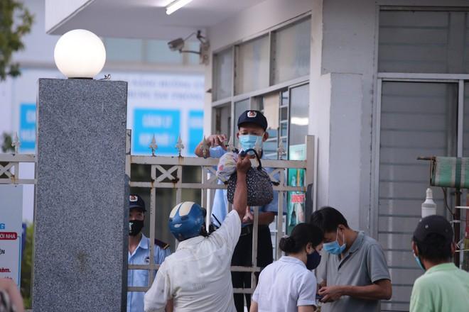 Người nhà gửi đồ dùng cho bảo vệ bệnh viện chuyển vào cho những người đang cách ly gửi bên trong