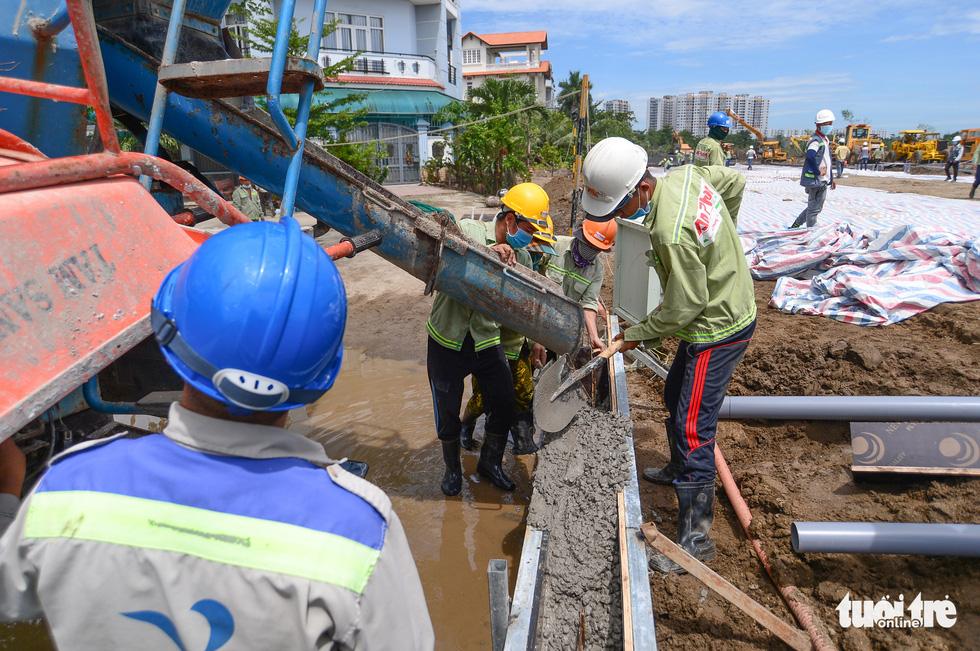 Công nhân đổ bêtông thi công hàng rào dự án