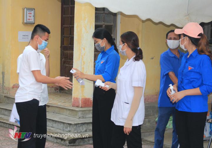 Thí sinh được đo thân nhiệt và hướng dẫn sát khuẩn trước khi vào điểm thi.
