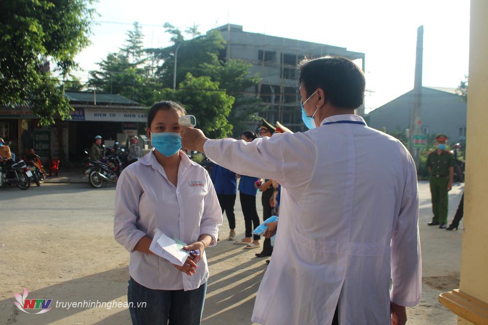 Đo thân nhiệt cho thí sinh trước khi vào điểm thi.