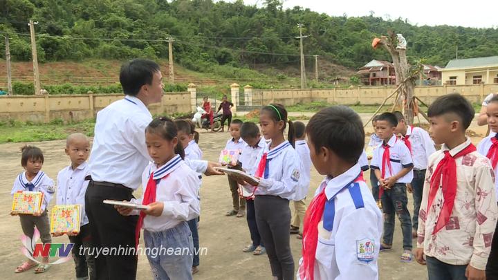 Thầy cô giáo tặng vở cho học sinh nhân dịp khai giảng.