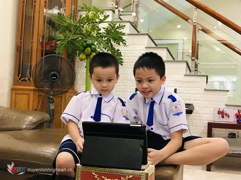 Em Hoàng Gia Hưng học sinh lớp 4H cùng em trai Hoàng Khánh Toàn lớp 1H trường Tiểu học Thị Trấn cùng xem lễ khai giảng năm học mới.