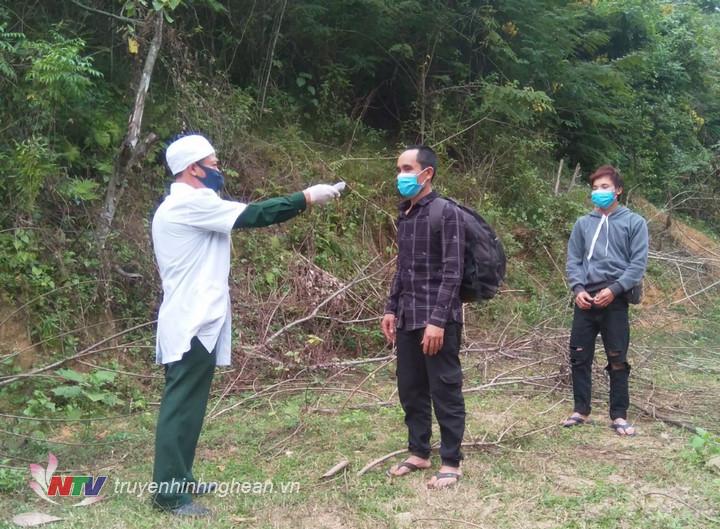 Lực lượng chức năng tiến hành kiểm tra, đo thân nhiệt cho 2 đối tượng vượt biên trái phép.