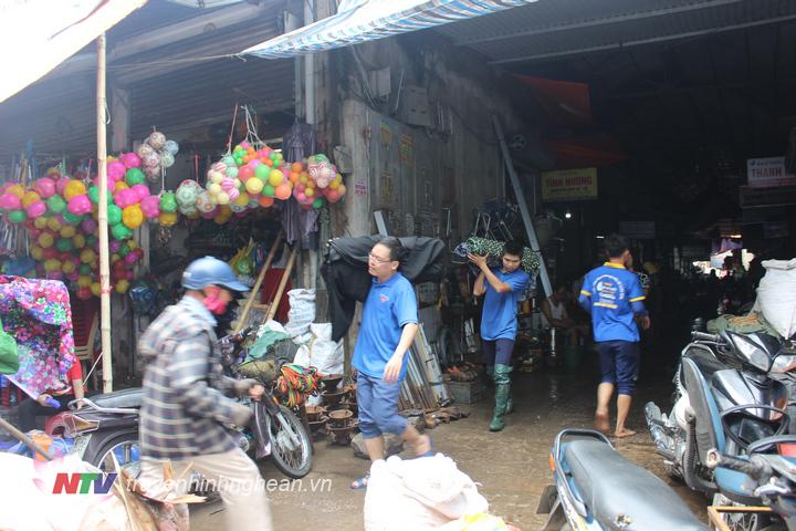 Đoàn viên thanh niên hỗ trợ các tiểu thương chọ Vinh di dời hàng hóa bị ngập nước.