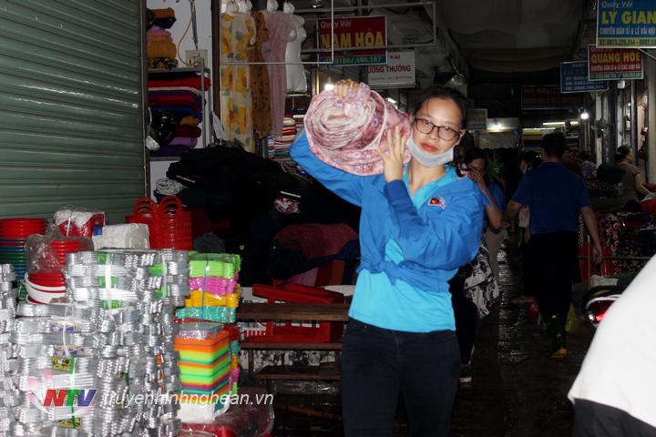 Đoàn viên thanh niên hỗ trợ các tiểu thương chọ Vinh di dời hàng hóa bị ngập nước.